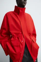 Parka de corte regular confeccionada en tejido técnico repelente al agua. Presenta cuello subido ajustable con cordón, cierre frontal con cremallera oculta por solapa con botones a presión, bolsillos de plastrón con solapa en la cadera y cintura ajustable con cordón. Incluye un forro interior acolchado desmontable.