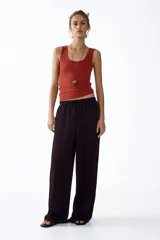 Pantalón de punto color marrón oscuro, de tiro alto con cintura elástica, cordón de ajuste y diseño de piernas amplias.