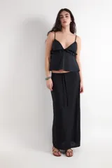 Falda larga de corte recto y tiro bajo en color negro, confeccionada en tejido plano dobby con textura rústica de mezcla de lino y viscosa. Cuenta con un cordón ajustable en la cintura.