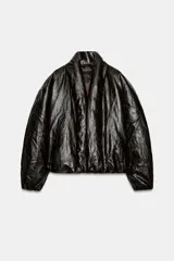 Cazadora acolchada Zara de efecto piel en color negro, con cuello en pico, manga larga, bolsillos delanteros y cierre frontal cruzado con botón.