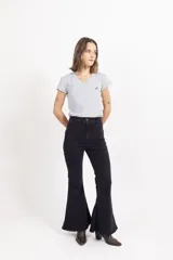 Jean oxford de tiro alto en color negro, confeccionado en denim con elasticidad. Presenta un corte ajustado en la parte superior y acampanado desde la rodilla hacia abajo, con cierre frontal y bolsillos.