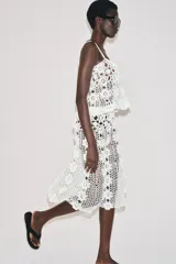 Falda midi blanca de crochet con cintura elástica, diseño de tejido con estructura en forma de flor y bajo en evasé.