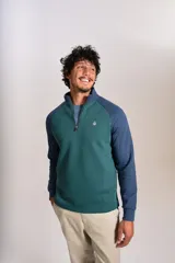 Buzo de cuello alto con cierre frontal parcial, diseño bicolor con cuerpo en verde y mangas raglán en azul. Presenta el logo de la marca bordado en el pecho.