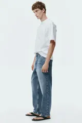 Jean de corte holgado estilo loose, confeccionado en denim de algodón grueso en tono azul claro con lavado desgastado. Presenta diseño de cinco bolsillos, tiro bajo y pierna ancha y redondeada.