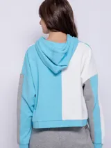 Canguro deportivo para mujer, con capucha y diseño color block en celeste, blanco y gris.