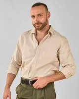 Camisa de vestir color beige, de corte clásico, con cuello americano, manga larga y bolsillo en el pecho.