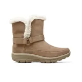 Bota casual Skechers de gamuza color marrón, con forro interior de piel sintética en el borde superior. Presenta una tira decorativa con hebilla metálica en el tobillo y suela de goma con tecnología de amortiguación.