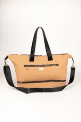 Bolso de gran capacidad color beige, con asas fijas superiores y correa de cinta negra desmontable y regulable. Presenta un bolsillo externo con cierre, un compartimento inferior con cierre y logo de la marca Daniel Cassin en el frente.