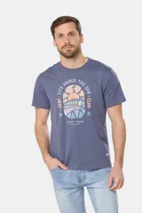 Remera de cuello redondo y manga corta, confeccionada en tejido de algodón con acabado jaspeado. Presenta un estampado frontal con temática de surf y estilo retro en tonos pasteles.