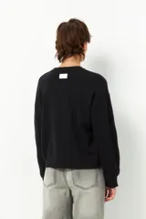 Sweater color borgoña de manga larga, tejido tramado y cuello redondo con puños elastizados.