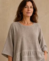 Blusa color visón con cuello redondo, mangas amplias de corte holgado y detalle de volados en la parte inferior.