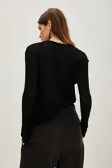 Sweater de punto fino y semitransparente, color negro, con cuello redondo y mangas largas.