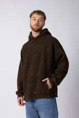 Buzo canguro con capucha, de calce oversize y diseño con recortes horizontales. Presenta un acabado efecto gastado y bolsillo frontal tipo canguro.