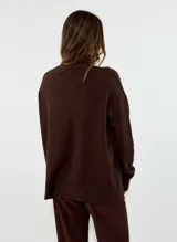 Sweater de punto con cuello alto, manga larga y puños acanalados. Presenta un diseño de corte holgado y tejido suave.