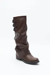 Bota de caña alta color negro, con diseño utilitario, puntera redondeada y taco bajo. Presenta un efecto fruncido en la caña y tres hebillas metálicas decorativas.