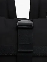 Mochila negra de poliéster con diseño de solapa enrollable y cierre de apertura rápida con hebilla. Presenta un parche con el logo de Tommy Jeans en la parte inferior frontal.