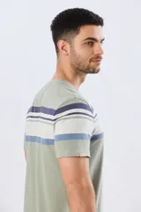 Remera de algodón y poliéster color verde militar con diseño de rayas horizontales en tonos azules, blancos y celestes en la parte superior del pecho. Cuenta con cuello redondo y mangas cortas.