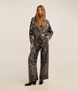Pantalón pantalona de cintura alta marca Marfinno, confeccionado en mezcla de viscosa y lino, con estampa paisley en tonos negro y crudo, bolsillos laterales y trabillas para cinturón.