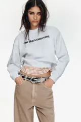 Sudadera de cuello redondo y manga larga en color gris jaspeado. Presenta un texto estampado en color negro en la parte frontal y acabados en rib a tono en cuello, puños y ruedo.
