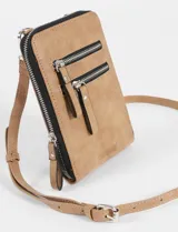 Porta celular de cuero sintético color marrón, con diseño rectangular, cierre principal y dos bolsillos frontales con cierre. Incluye correa larga regulable y extraíble, y cuenta con el logo de la marca grabado en la parte inferior.