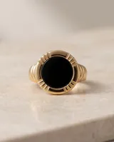 Anillo de plata y oro 18k con diseño central redondo y piedra de ónix negra.