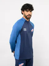 Buzo de entrenamiento Umbro del Club Nacional de Football, con medio cierre frontal, cuello alto y mangas largas. Presenta el logo de la marca y el escudo del club en el pecho.