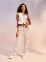 Pantalón de tiro alto color negro, confeccionado en mezcla de lino. Presenta corte recto con pinzas en la cintura, bolsillos laterales y un detalle de ajuste con lazo en los tobillos que crea un efecto acampanado.