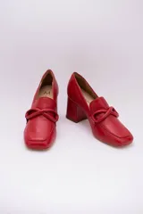 Zapato de cuero rojo con aplique decorativo en el empeine y tacón cuadrado.