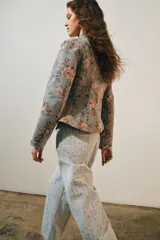 Blazer de jacquard de algodón con estampado floreado, cuello subido, manga larga y cierre frontal con botones. Presenta bolsillos de plastrón en el delantero, detalle de aplicación de lentejuelas, forro interior a tono y bajo asimétrico.