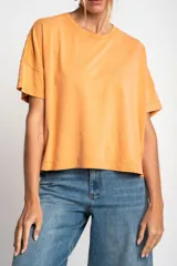 Remerón color naranja de algodón peinado con calce oversize y mangas cortas con dobladillo.