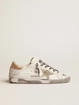 Zapatillas Golden Goose Super-Star de cuero blanco con efecto desgastado, estrella lateral y talón de cuero metalizado dorado, cordones con estampado animal print de leopardo, y detalles manuscritos en la puntera.
