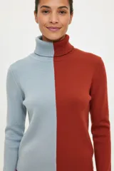 Polera de cuello alto con diseño bicolor, presentando una mitad en color celeste y la otra mitad en color terracota. Confeccionada en tejido de punto acanalado, de manga larga y ajuste al cuerpo.