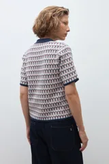 Sweater de punto con diseño jacquard, cuello polo con cierre de botones y mangas cortas con terminación en contraste.