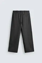 Pantalón de corte regular fit confeccionado en mezcla de algodón y lino. Presenta cintura elástica con cordón ajustable, cierre frontal con cremallera y botón, bolsillos laterales y bolsillo trasero de vivo con botón.