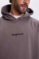 Canguro con capucha color marrón, de corte holgado, con bordado frontal con la palabra "California" en negro.