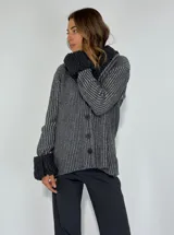 Saco marrón con rayas verticales en tonos beige, con cuello y puños de tejido rizado. Cierre frontal con botones.