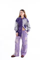 Camisa oversize bicolor en tonos violeta y gris, confeccionada en casimir de lana liviano. Presenta cuello clásico, cierre frontal con botones, bolsillo en el pecho y mangas largas con puños abotonados.