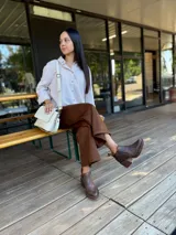 Botas cortas de cuero con efecto desgastado en color chocolate, con taco cuadrado y plataforma. Presentan cierre lateral y punta redondeada.