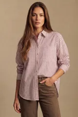 Camisa de corte oversize con estampado de rayas verticales, cuello clásico, cierre frontal con botones y bolsillo en el pecho. Presenta mangas largas con puños abotonados y un diseño fluido.