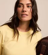 Blusa amarilla de mangas cortas con cuello redondo y bajo con flores bordadas.