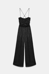 Mono largo de pierna ancha con escote recto y cuerpo superior con frunces. Presenta tirantes finos ajustables que se cruzan en la espalda y cierre lateral oculto.