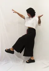 Falda larga de estilo deportivo confeccionada en tejido de algodón y poliéster. Presenta cintura elástica con cordón de ajuste en color fucsia, bolsillos laterales y un aplique decorativo de acrílico en la parte frontal.