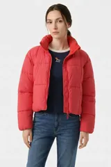 Campera puffer corta de color rojo, con diseño acolchado de bloques, cuello alto y cierre frontal con cremallera.