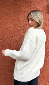 Sweater de punto en color crudo melange, con cuello redondo, mangas largas con puños ajustados y diseño de corte holgado.