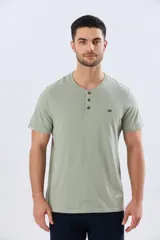 Remera básica de manga corta y cuello redondo, color bordó, con cartera de botones en el pecho y pequeño bordado al tono.