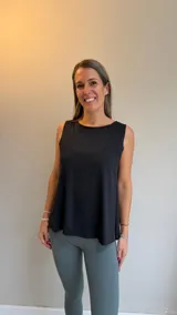 Musculosa deportiva negra de corte holgado, con cuello redondo y aberturas laterales que brindan mayor libertad de movimiento.