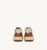 Zapatillas urbanas Autry modelo Super Vintage Low, color blanco con detalles en negro y rojo. Diseño con efecto envejecido, cordones color crema y suela de goma marrón.