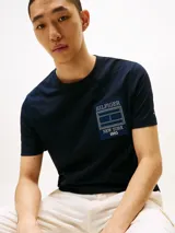Remera de cuello redondo confeccionada en puro algodón, con corte regular. Presenta un parche rectangular con el logo de Tommy Hilfiger New York en el pecho y un pequeño logo bordado en la manga.