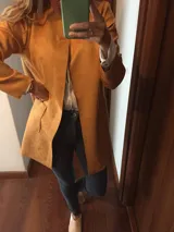 Blazer color camel, de corte recto y largo a la cadera, confeccionado en tela símil gamuza.