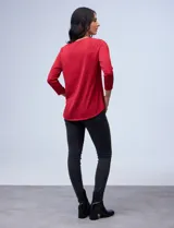 Blusa negra texturada de Robert Louis con escote en V, cierre metálico y mangas tres cuartos.